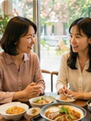 50代の女性が、30代後半の女性とランチを食べながら穏やかに話を聞く。